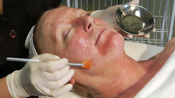 Lactic acid peel professional spa application: anti-aging esthetician class for dry skin using a treatment brush.